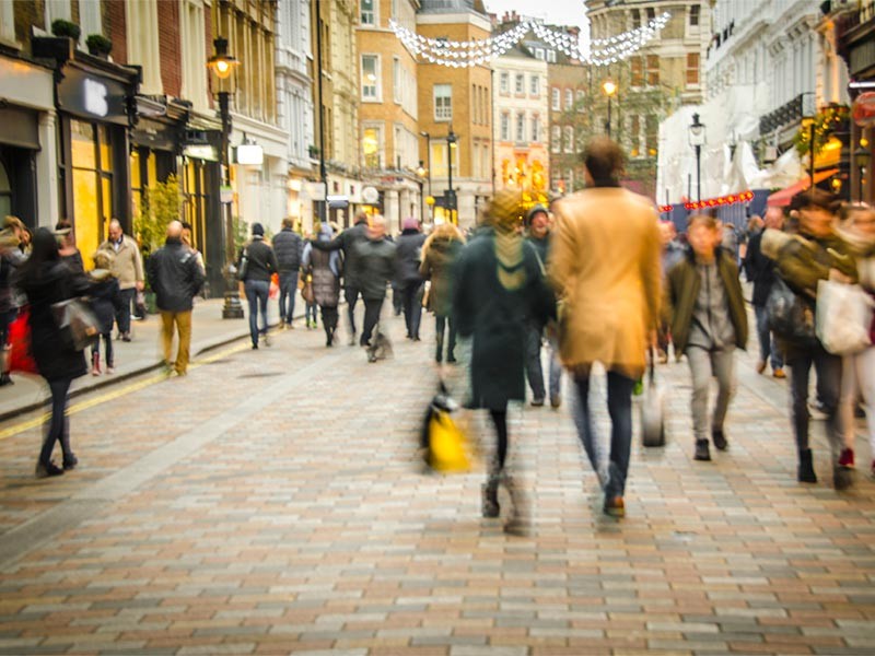 Motion blurred shoppers on busy high street